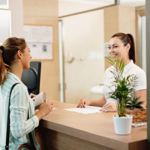 happy-woman-talking-receptionist-while-arriving-spa.jpg